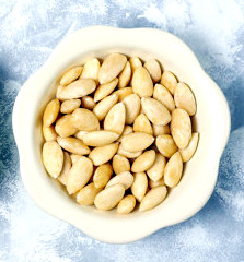 Peeled (blanched) and unblanched whole almonds in ceramic bowls